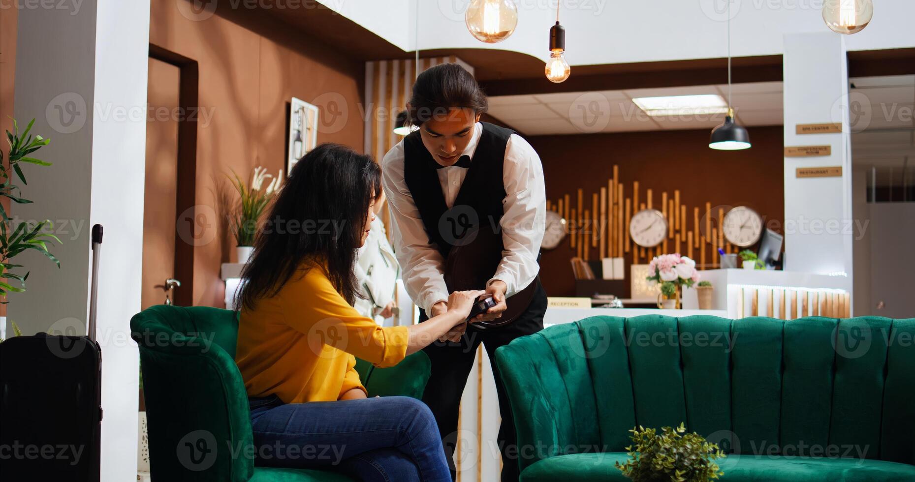 Woman traveler paying for coffee on pos terminal, buying drink to relax after long flight. Client sitting in lounge area waiting for check in, making electronic transaction with credit card. photo