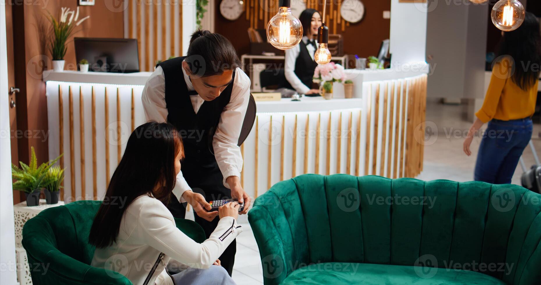 Pleased client giving cash to waiter after paying for coffee, using pos terminal for credit card payment and enjoying good customer services at five star hotel. Woman offering money to staff. photo