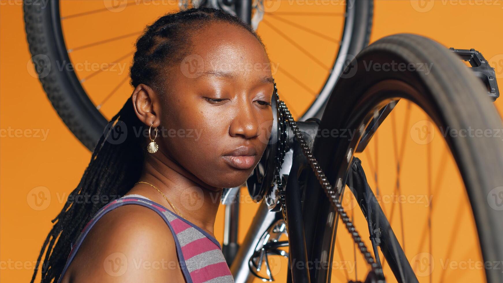 Close up of mechanic pushing pedals to spin bike wheel, examining it after mending and lubricating parts. Employee listening for any sign of squeakiness in noisy bicycle chain rings, camera A photo