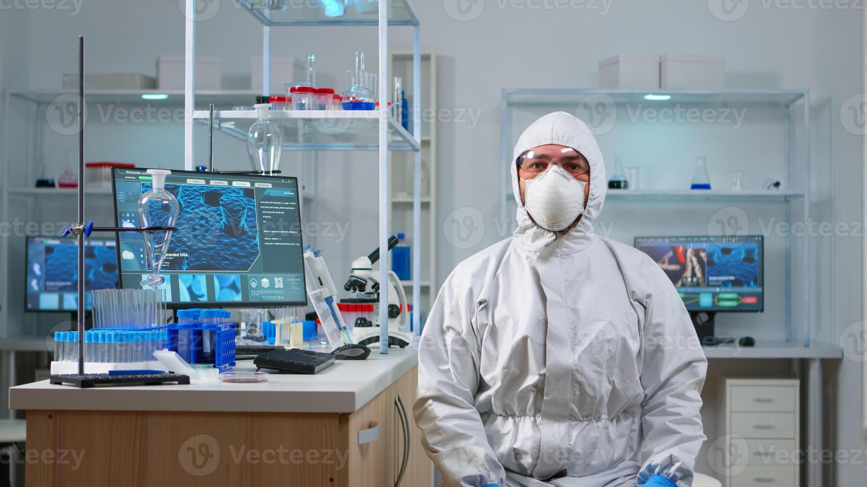 Lab technician in ppe suit working with virtual reality in chemical laboratory. Team of biologists examining vaccine evolution with high tech and technology researching treatment against covid19 virus photo