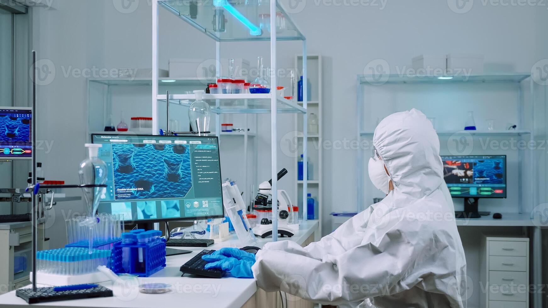 Chemist typing on pc and coworker analysing microscope slides in equipped laboratory. Team of scientists examining vaccine evolution using high tech for researching treatment against covid19 virus photo