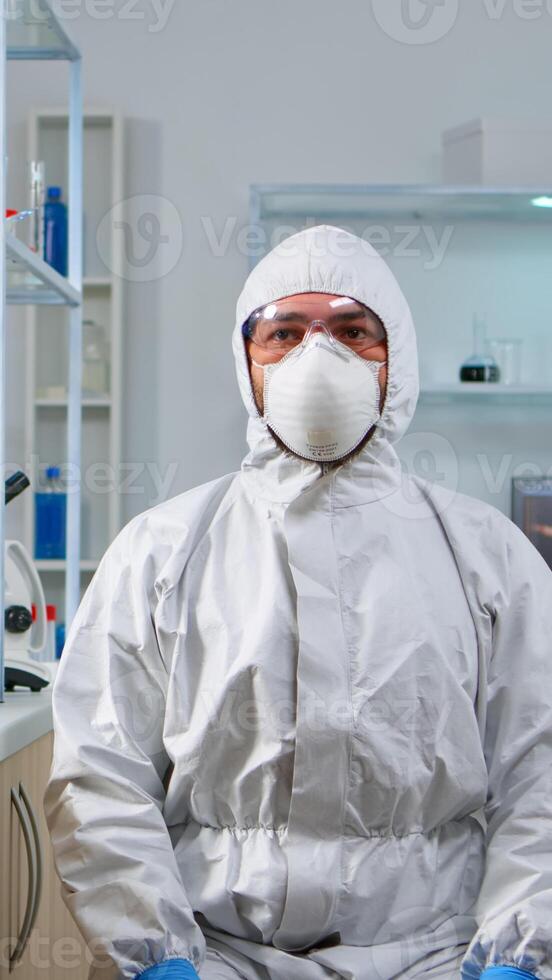 Lab technician in ppe suit working with virtual reality in chemical laboratory. Team of biologists examining vaccine evolution with high tech and technology researching treatment against covid19 virus photo