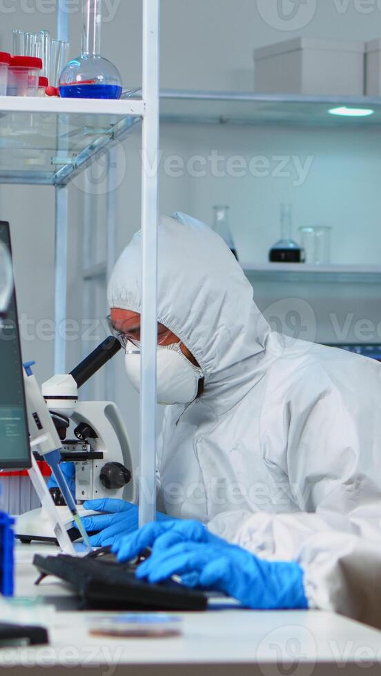 Scientists in protection suits working in chemical equipped laboratory. Team of biologists examining vaccine evolution using high tech and technology researching treatment against covid19 virus photo