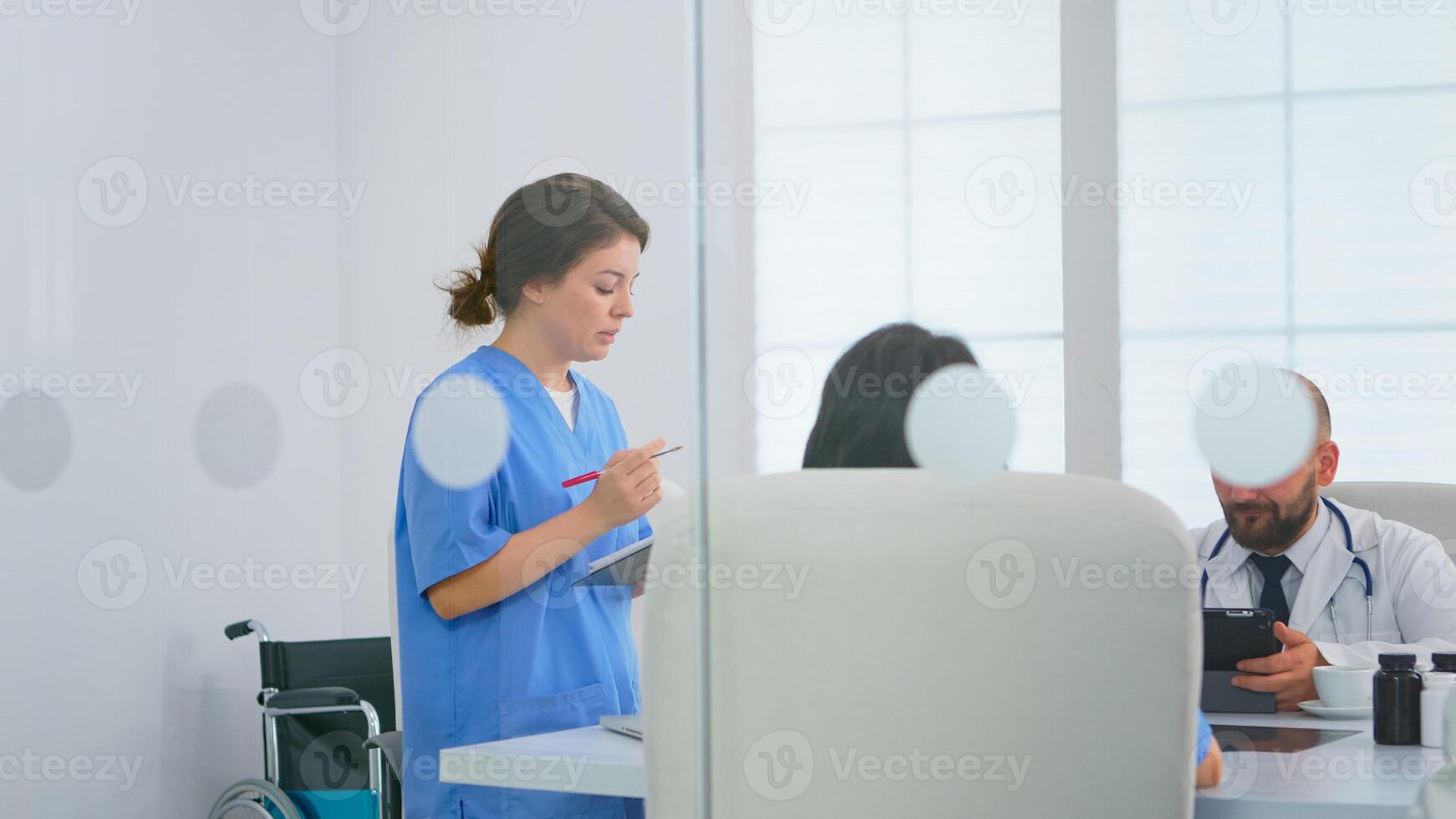 Nurse talking in front of teamworkers about research informtions and treatment development during brainstorming in meeting room. Physicians discussing about symptoms of disease in clinic office photo