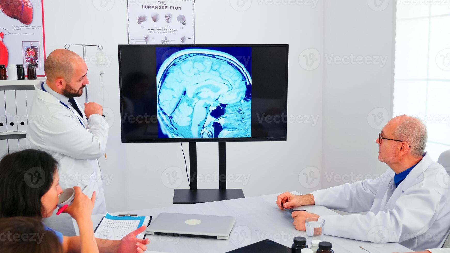 Physicians talking with specialist doctors during medical conference. Expert doctor using modern technology, pointing on digital radiography brainstorming with medicine staff for expertise. photo