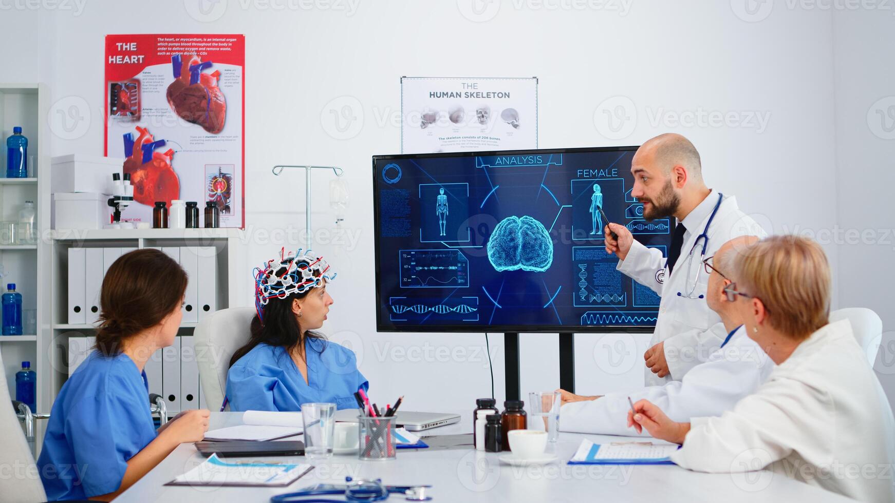 Neurologist showing new inovation to colleagues discussing brain functions using high tech in medical boardroom. Medic studying diagnosis of patients working in hospital conference room photo