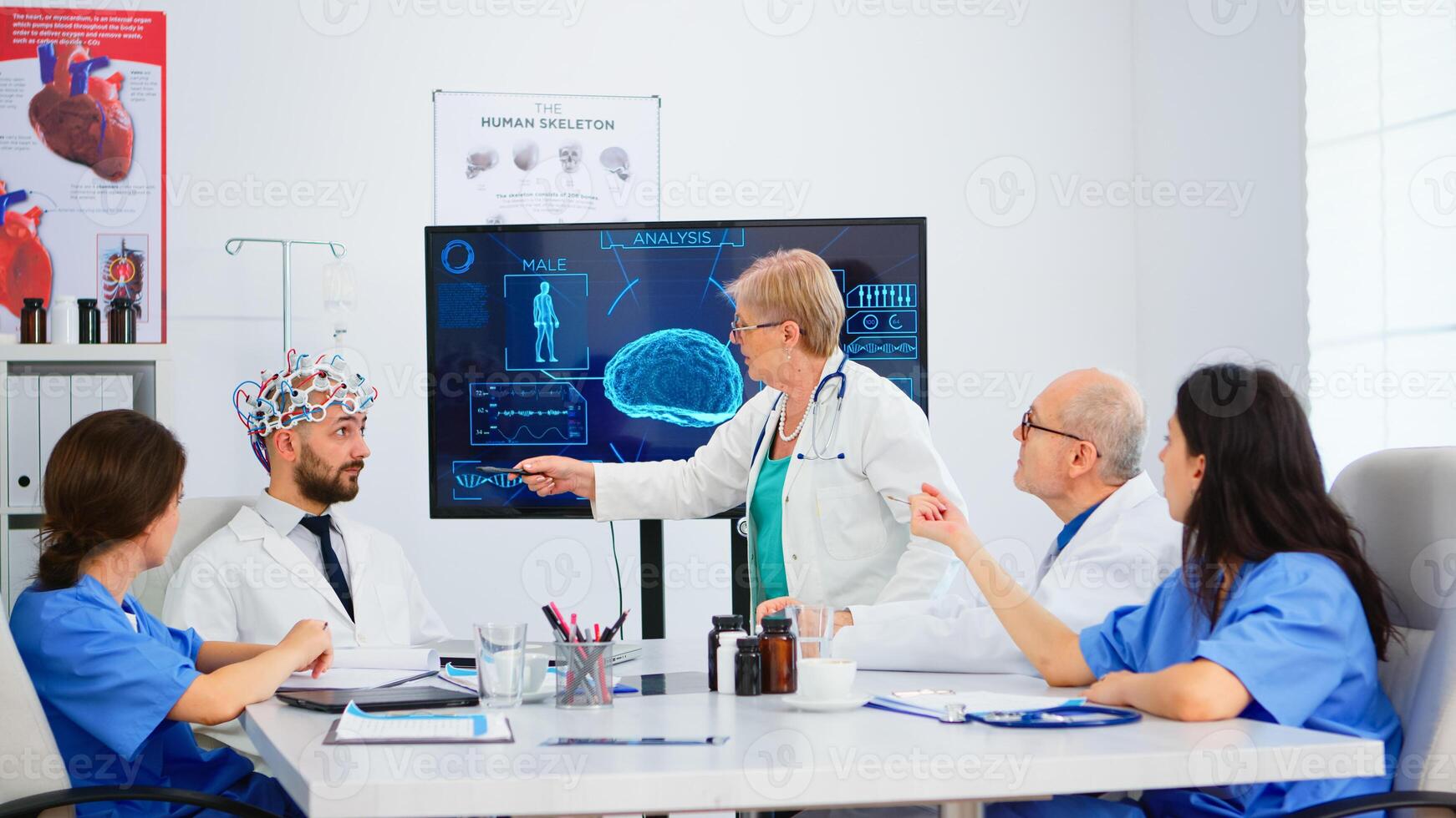 Senior woman neurologist analysing brain functions using high tech in medical conference room, doctor testing new innovation. Medic studying diagnosis for treatment of patients working in boardroom photo