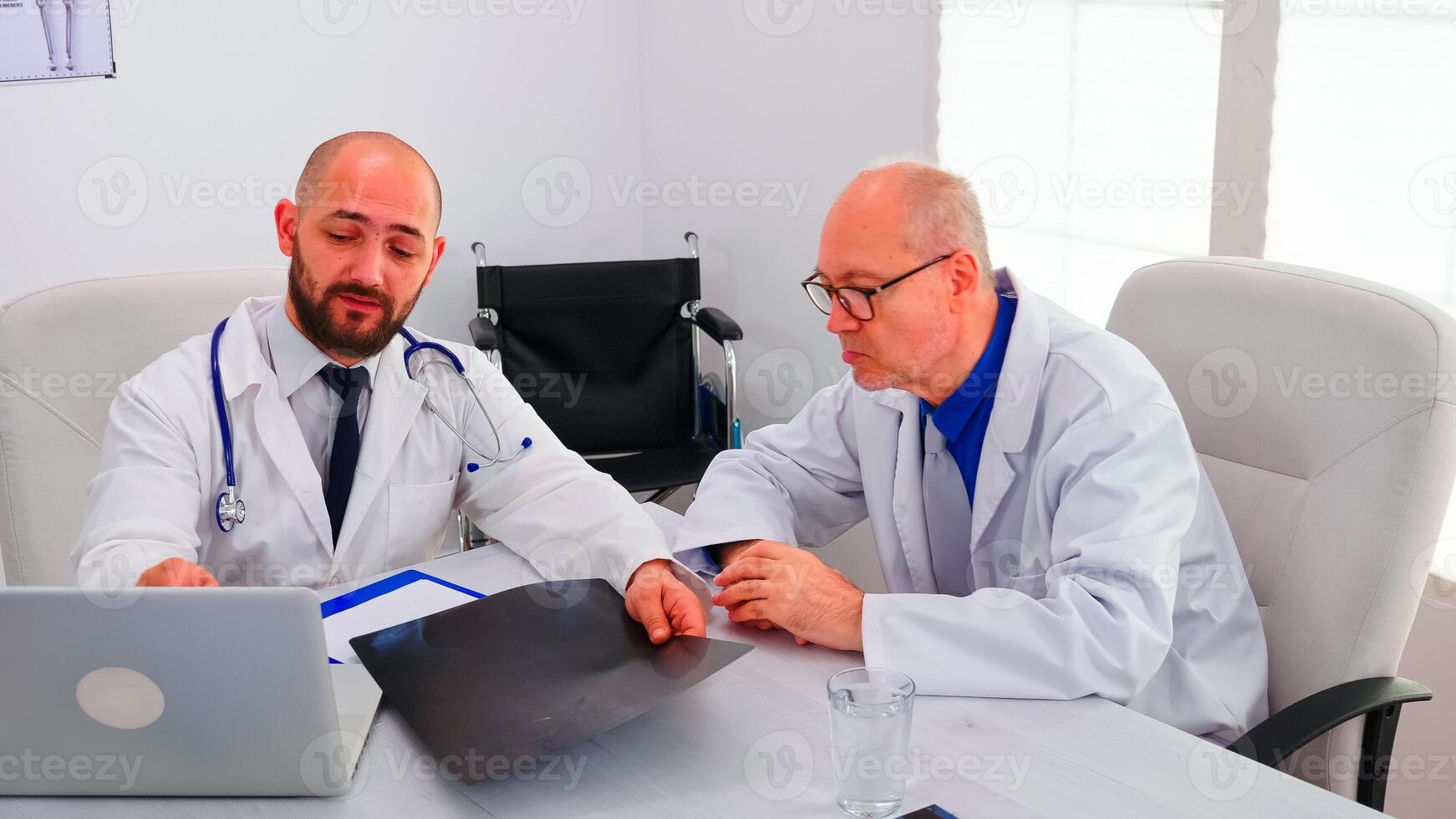 Group of doctors discussing about spine radiography of patient analysing his evolution working in hospital conferene room. Radiologist doctor talking with colleagues about symptoms and treatment photo