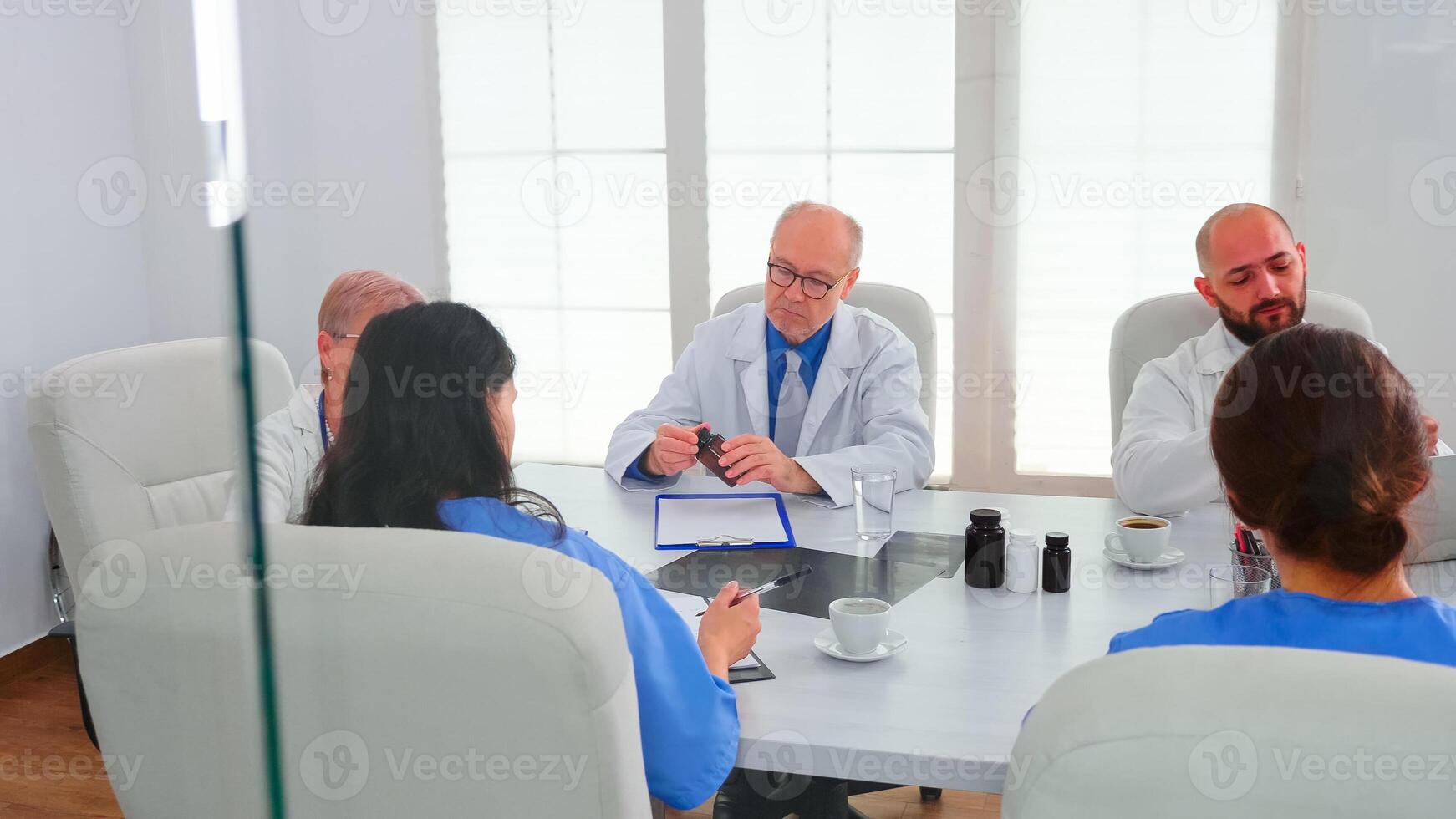 Team of doctors checking reports of patients, analysing waiting list and treatment development, nurse taking notes. Clinic expert therapist talking with colleagues about disease, medicine professional photo