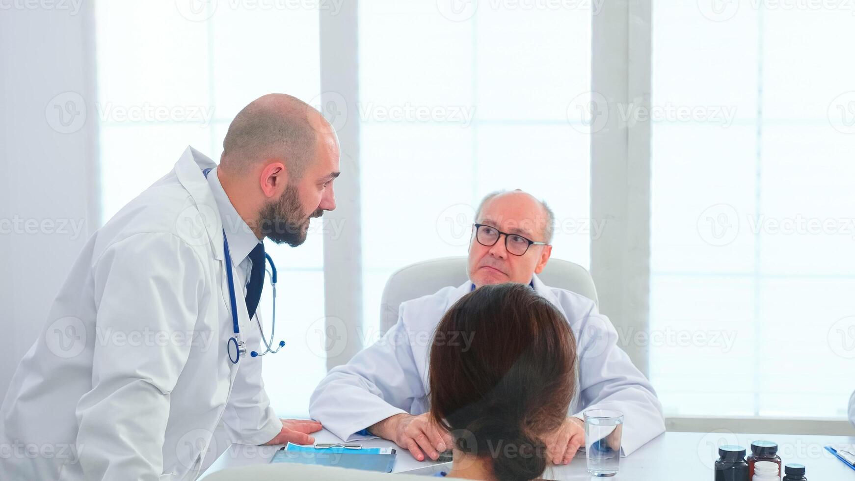 Team of doctors in hospital office setting diagnostic in hospital conference room. Clinic expert therapist talking with colleagues about disease, medicine professional working in boardroom photo