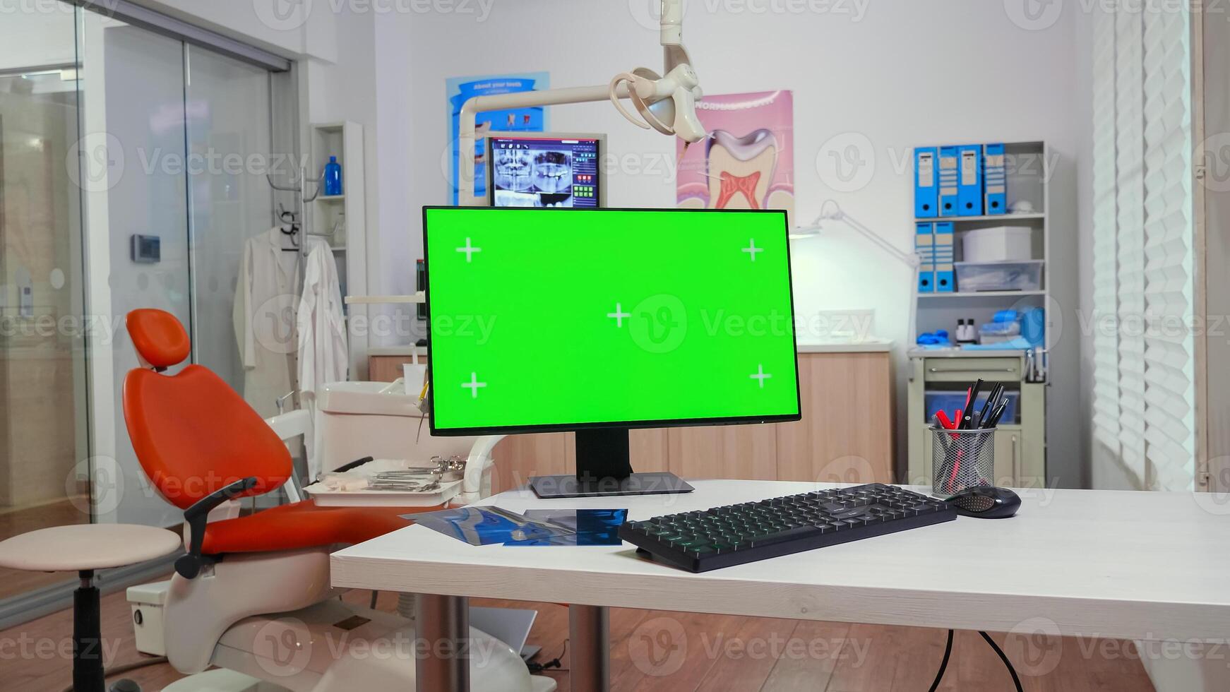 Computer with chroma key pc desktop placed in front of camera in empty equipped stomatological room. Stomatology clinic with nobody in it prepared for patient using green screen, mockup display photo