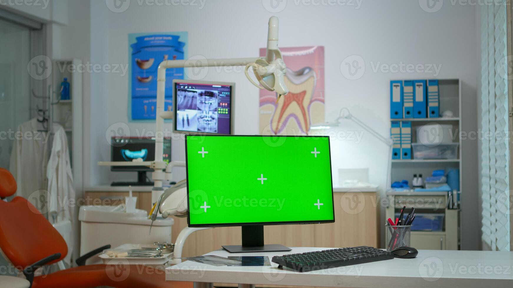 Computer with green screen placed in front of camera in empty modern equipped stomatological room. Stomatology clinic with nobody in it prepared for next patient with mock-up, chroma key pc display photo
