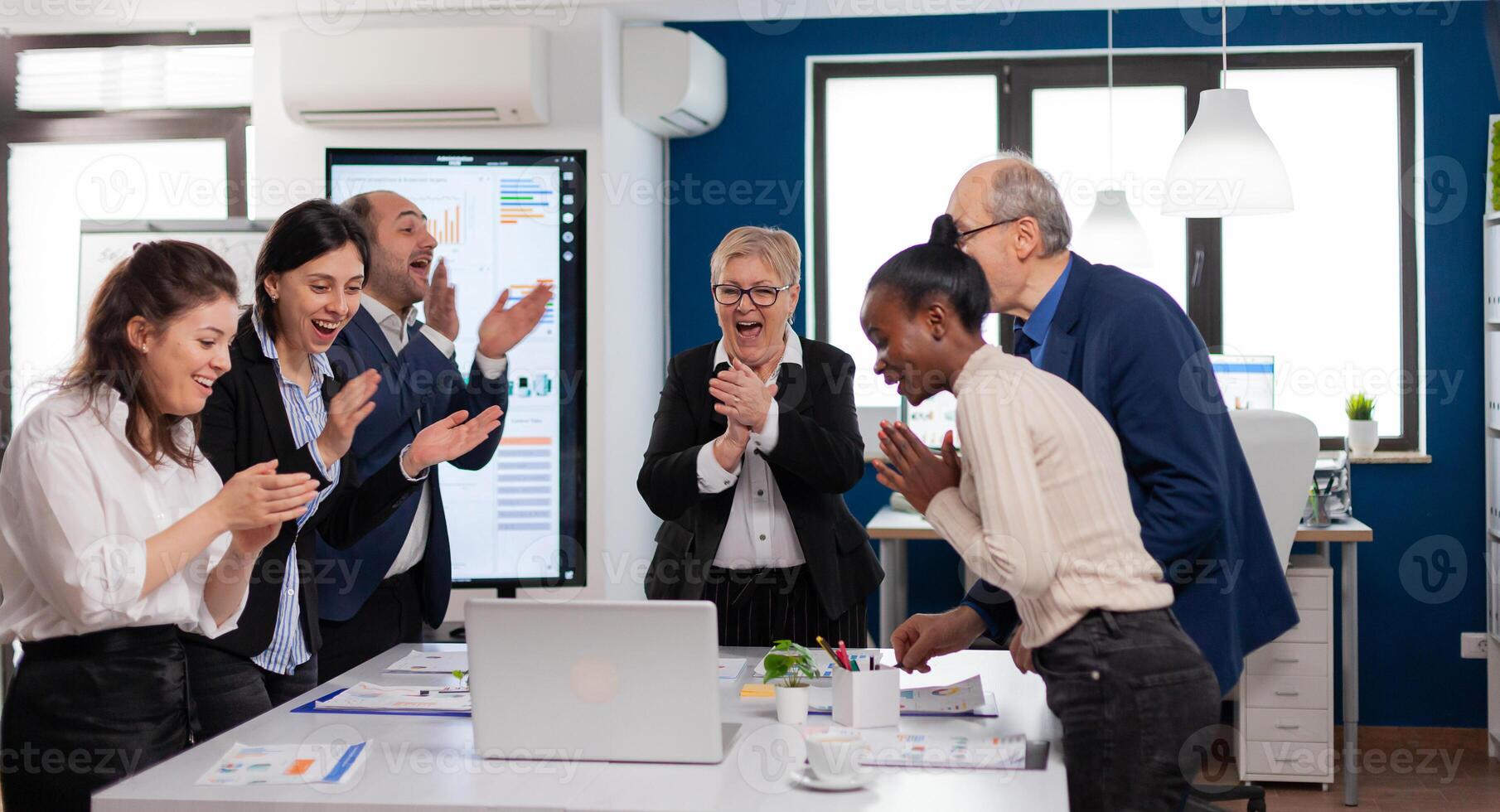 Motivated happy diverse business team people clapping celebrating success at corporate meeting. Multiethnical partners coworkers celebrate successful teamwork result at company briefing photo