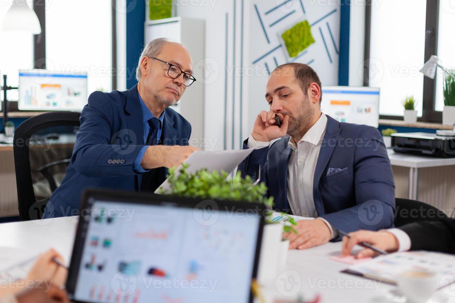 Financial entrepreneurs analysing discussing documents in corporate briefing room. Businessman discussing ideas with colleagues about financial strategy for new start up company. photo