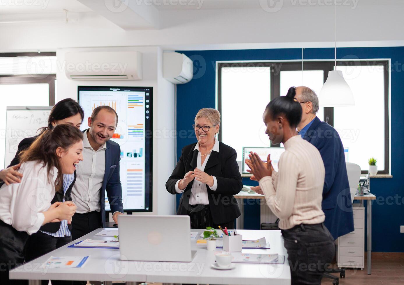 Management team clapping overjoyed in conference room after good training. Multiethnical partners coworkers celebrate successful teamwork result at company briefing photo