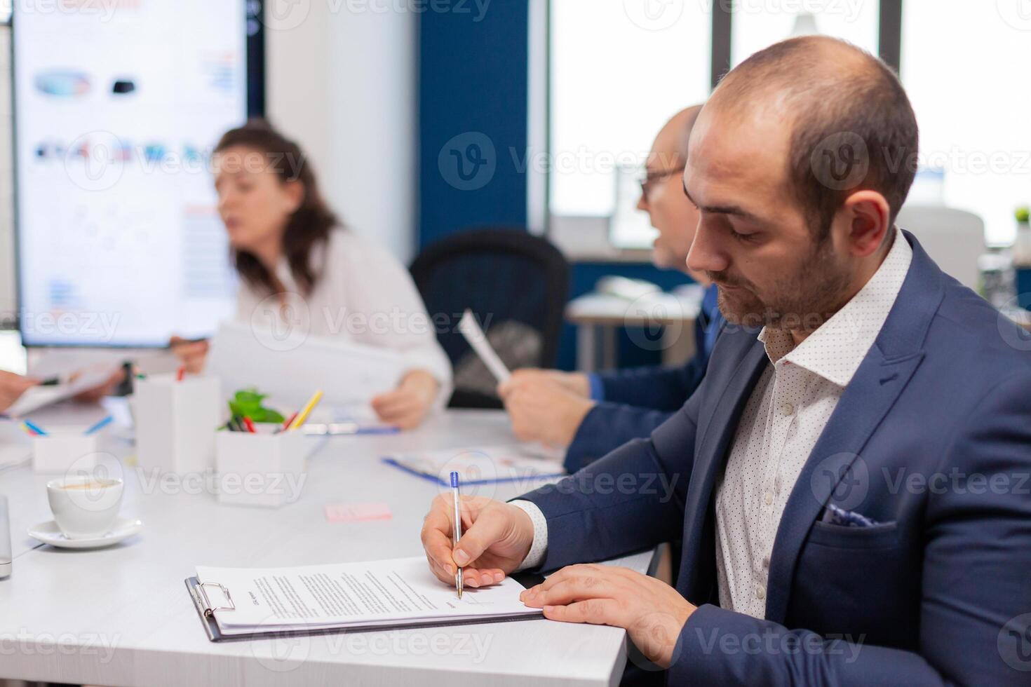 Businessman reading paper document, discussing contract with confident partner, signing investment papers. Executive director meeting shareholders in start up office, making satisfactorily agreement. photo