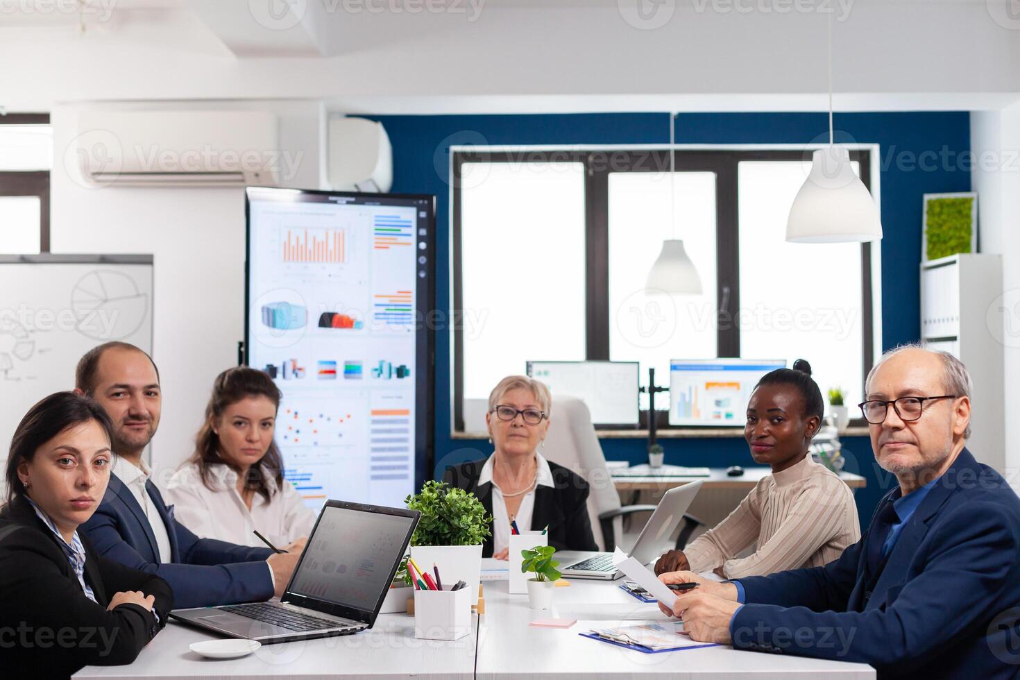 Pov of diverse team sitting in conference room during virtual meeting, discussing online with business partners. Internet conference call technology talk with investors, corporate brainstorming via web. photo