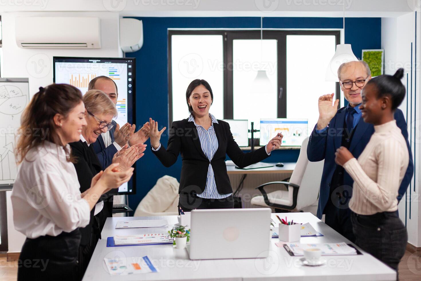 Motivated happy diverse business team people clapping celebrating success at corporate meeting. Multiethnical partners coworkers celebrate successful teamwork result at company briefing photo