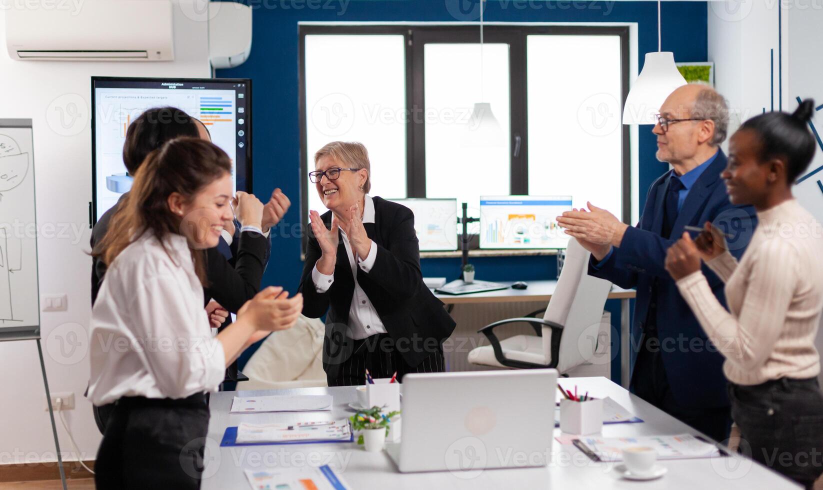 Happy diverse colleagues with new business opportunity enjoing victory. Multiethnical partners coworkers celebrate successful teamwork result at company briefing photo