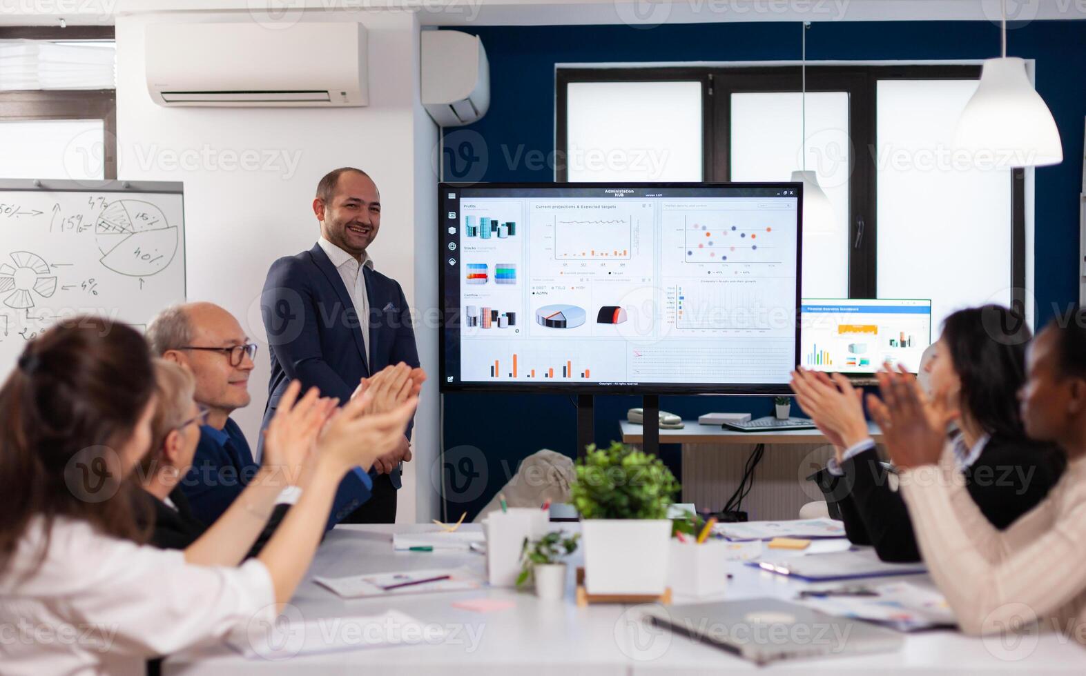 Succesful business man presenting the good evolution of company using digital device. Diverse multiethnic colleagues with new opportunity enjoing victory meeting in broadroom office. photo