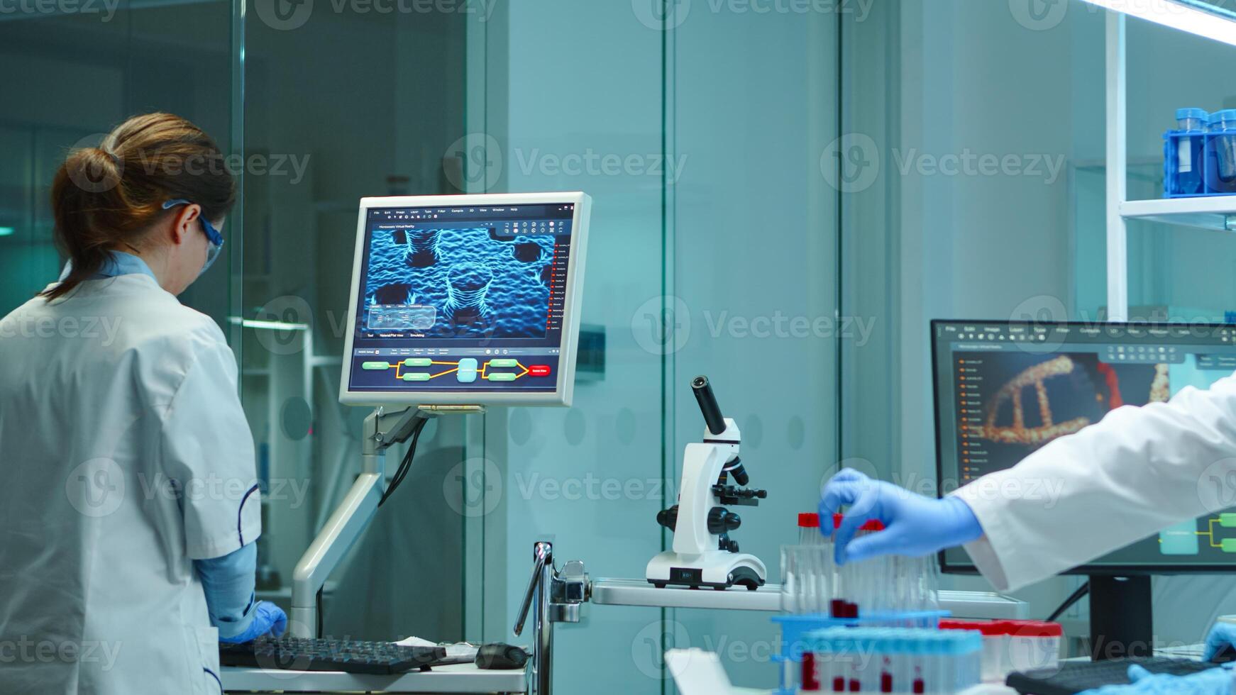 Chemist nurse working on computer in scientific modern equipped laboratory at night. Stuff examining vaccine evolution using high tech and technology researching treatment against covid19 virus photo