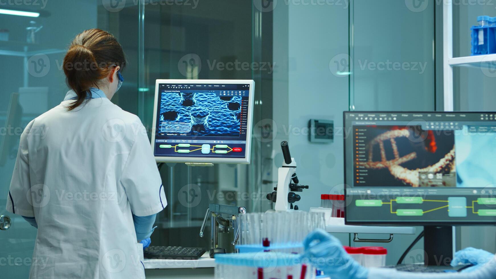 Scientist nurse typing medical reports on computer in scientific modern equipped laboratory. Examining vaccine evolution using high tech and technology researching treatment against covid19 virus photo
