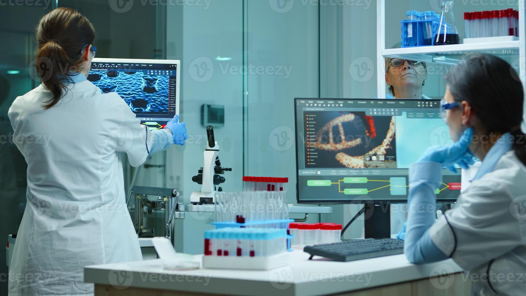 Scientists coworkers working in chemical modern equipped laboratory overtime. Doctors stuff examining vaccine evolution using high tech and technology researching treatment against covid19 virus photo