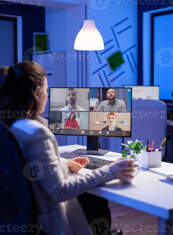 Start up manager working overtime late at night from business office talking online via web internet conference call with partners. Freelacner on videoconference corporate meeting using videocall chat photo