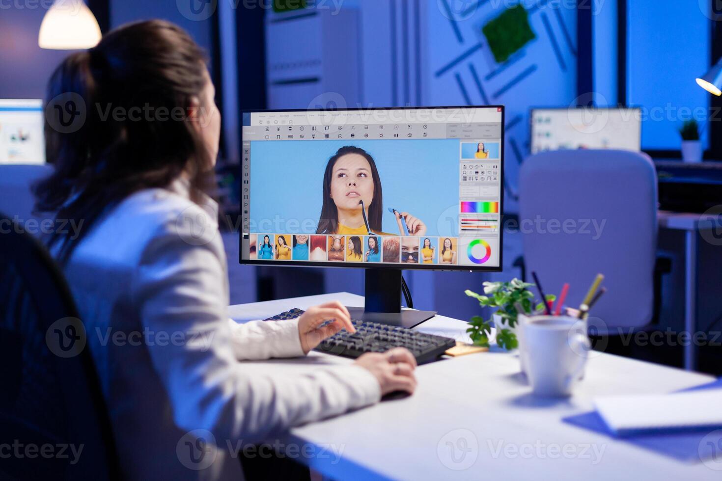 Creative creator doing portrait retouch using color grade late at night in professional editing office. Graphic editor retouching photos of a client on performance pc before deadline
