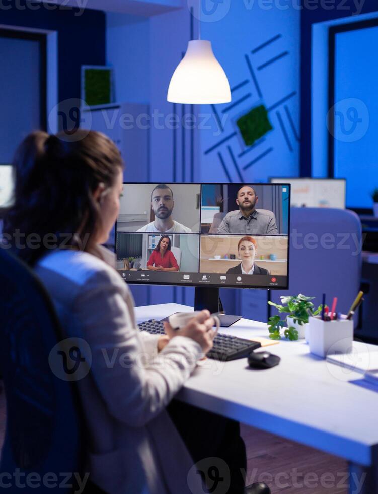 Start up manager working overtime late at night from business office talking online via web internet conference call with partners. Freelacner on videoconference corporate meeting using videocall chat photo