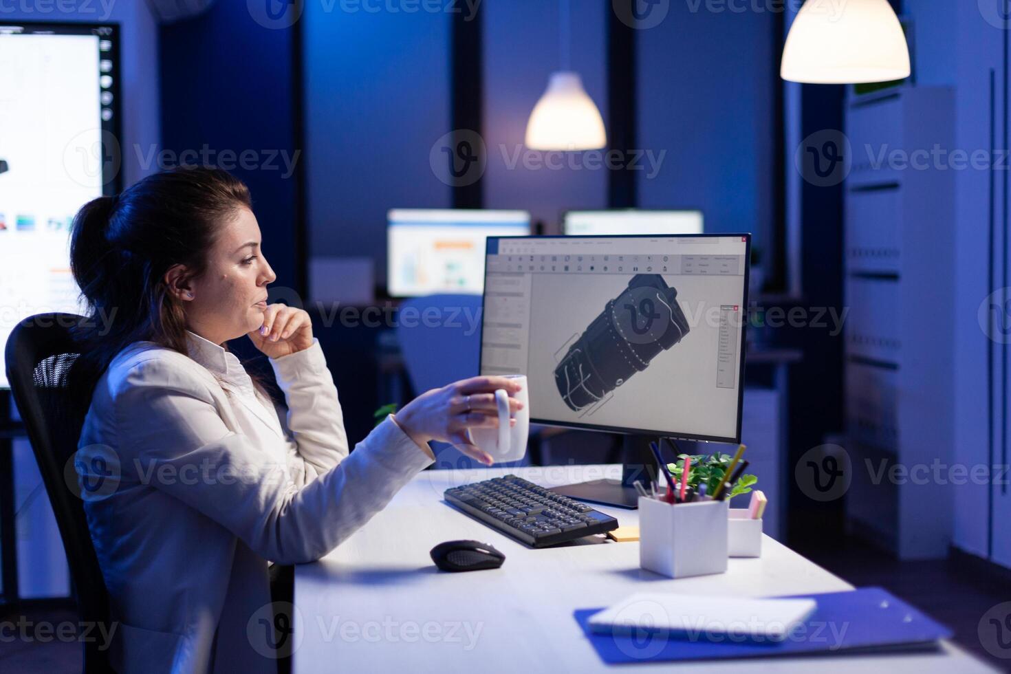 Project designer engineer analizing concept idea of 3D model of the plant yawning working overtime. Industrial woman worker studying turbine idea on pc showing cad software on device display photo
