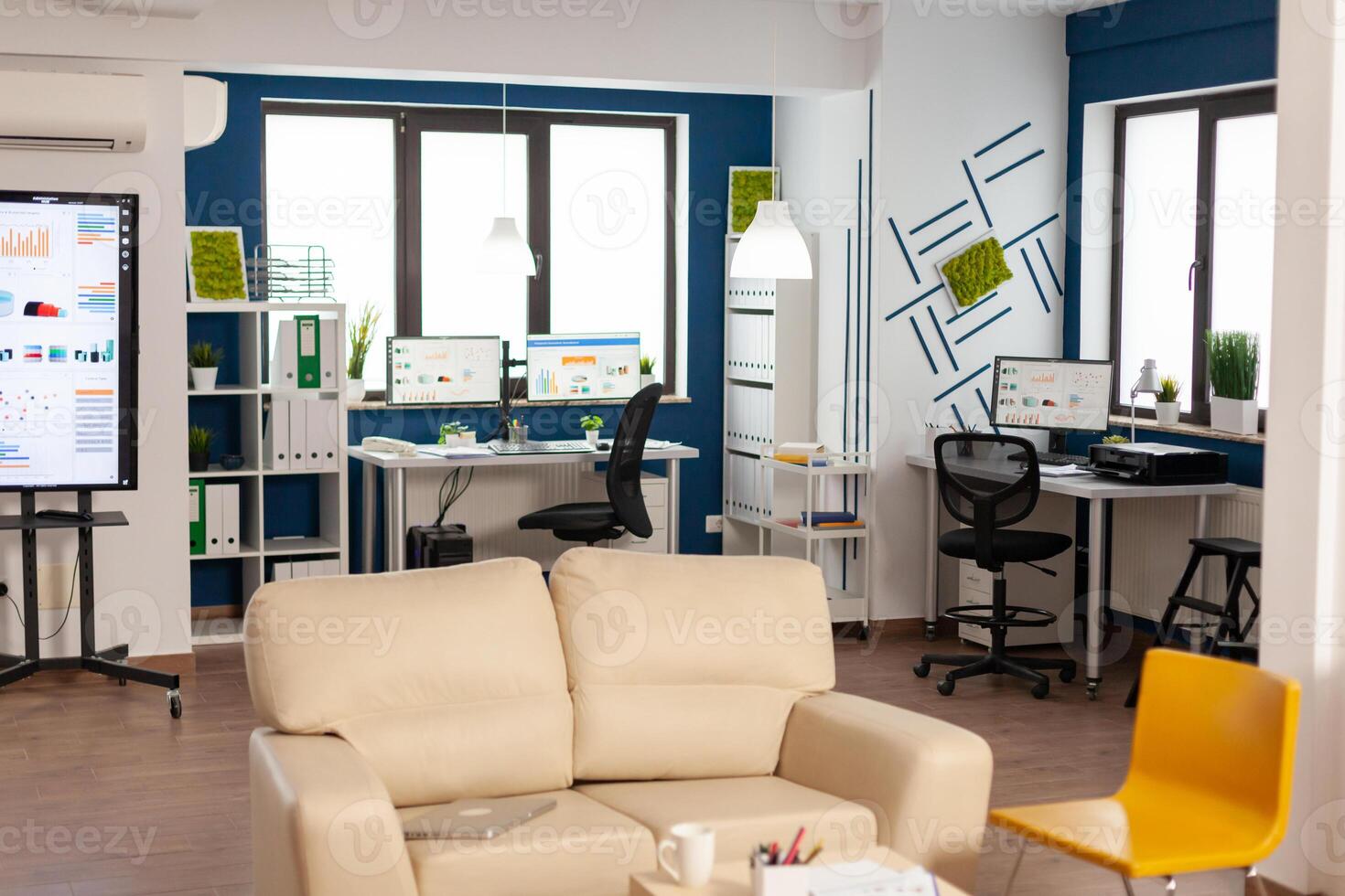 Interior of empty creative office with dusky light, new business, start up company with no people in it. Modern design and confortable couch with nobody in it, place of work startup photo