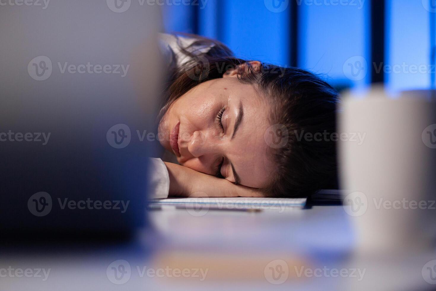 Entrepreneur working overtime on marketing project, falling asleep on desk while looking at financial documents trying to respect the deadline. Employee using modern technology network wireless photo
