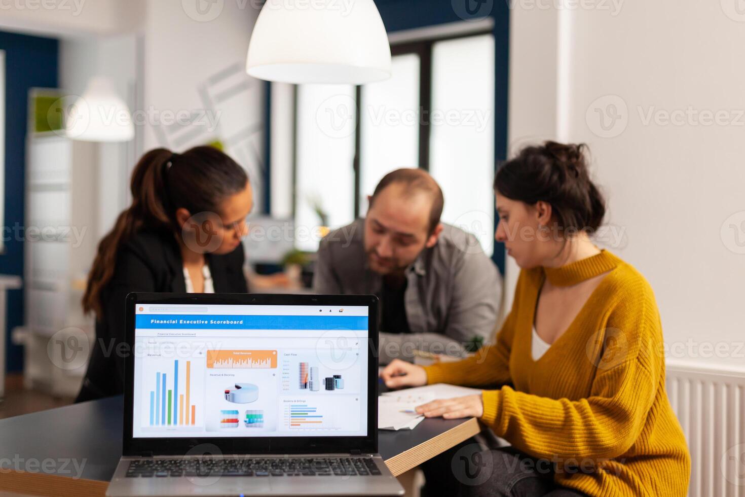 Business woman talking about financial project, taking notes, discussing start up ideas using laptop. Diverse employees gathered in co-working, working process in busy company, teamwork help concept photo