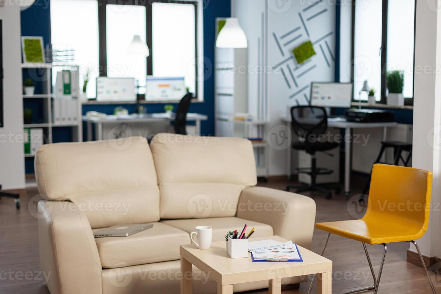 Interior of empty creative office with dusky light, new business, start up company with no people in it. Modern design and confortable couch with nobody in it, place of work startup photo