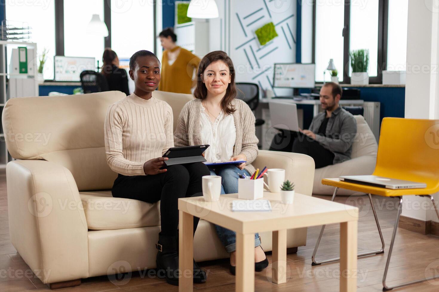Start up company teamwork talking during meeting sitting on couch listening and explaning to remote manager team strategy. Multiethnic coworkers discussing about startup financial project. photo