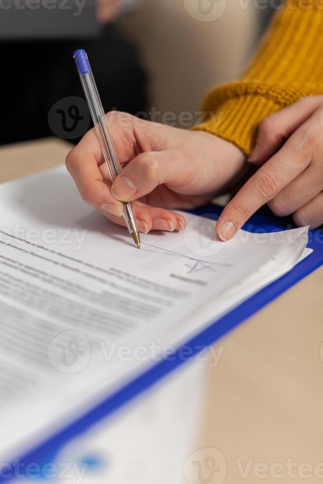 Businesswoman signing paper, partner hand puts signature on business document making employment contract agreement, taking bank loan insurance concept, patent certificate registration, close up view photo