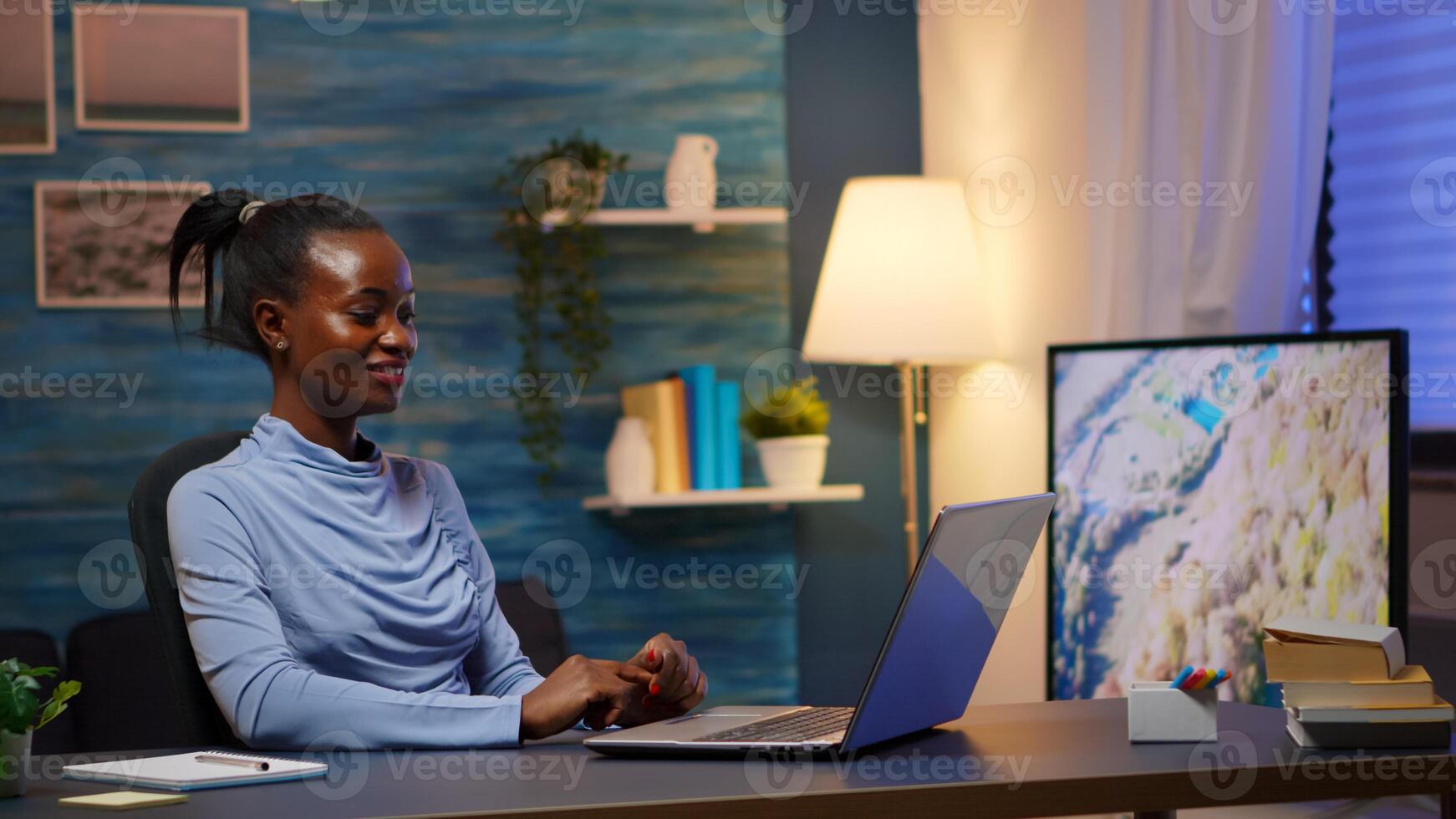 Black business woman discussing on webcam with partners sitting at home desk office. African freelancer working with remotely team chatting having virtual online conference, using internet technology photo