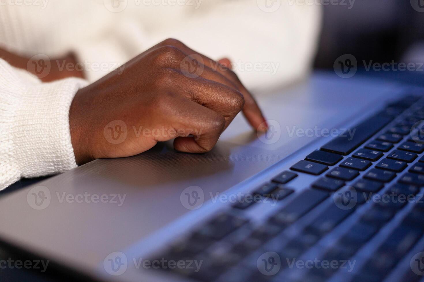 Close-up of african american businesswoman hands hand typing company strategy on laptop computer late at night in startup corporate office. Executive manager reading financial statistics document photo