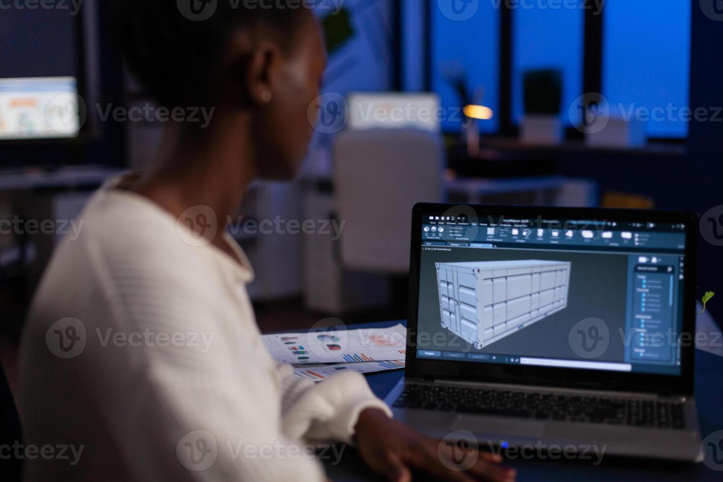 African american design arhitect working in 3D software developing prototype container idea working at night in corporate office. Technician engineer creating digital industrial project photo