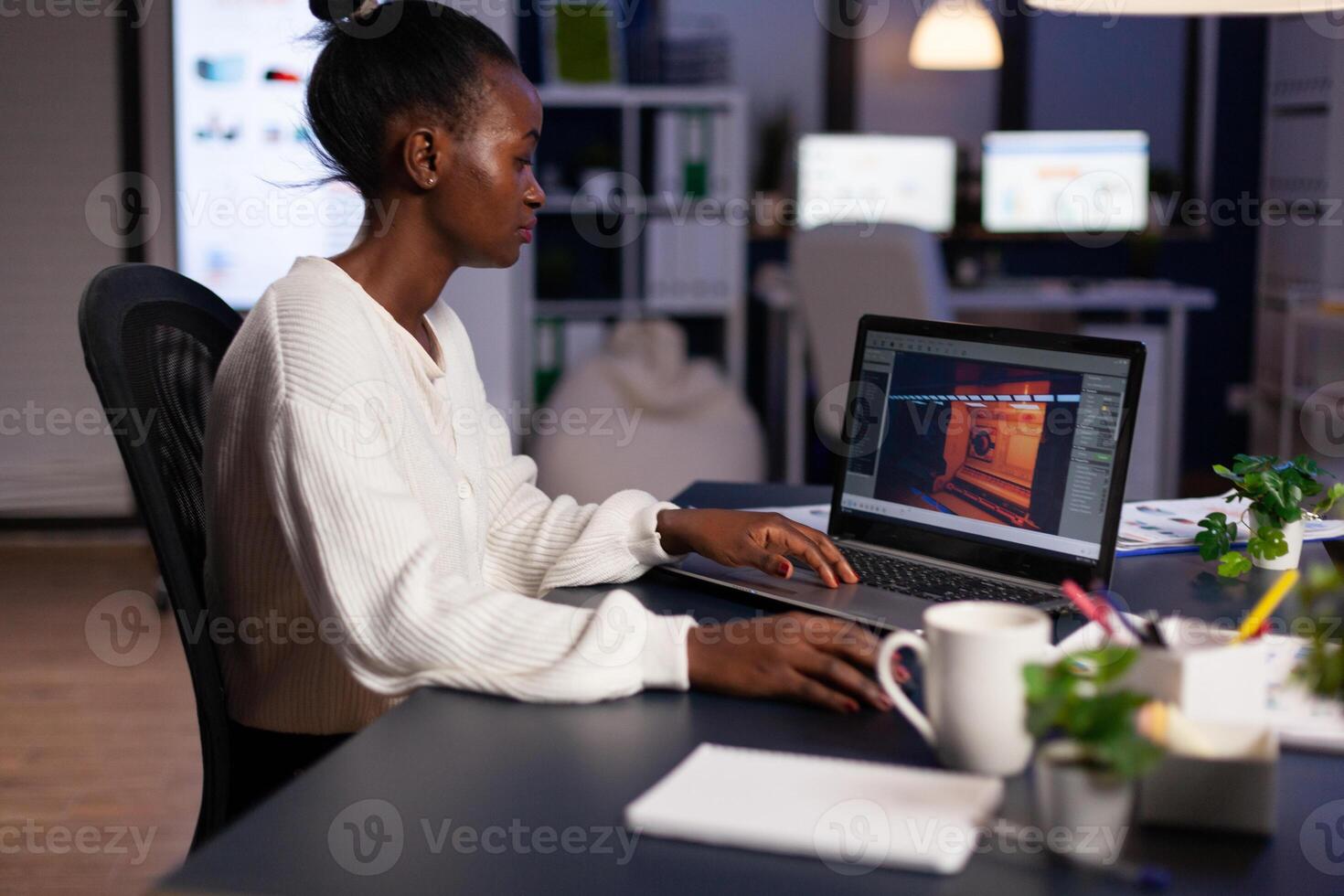 African american game developer testing new game working late at night in creativity agency company. Tired creator designer developing online games on pc using modern production technology photo