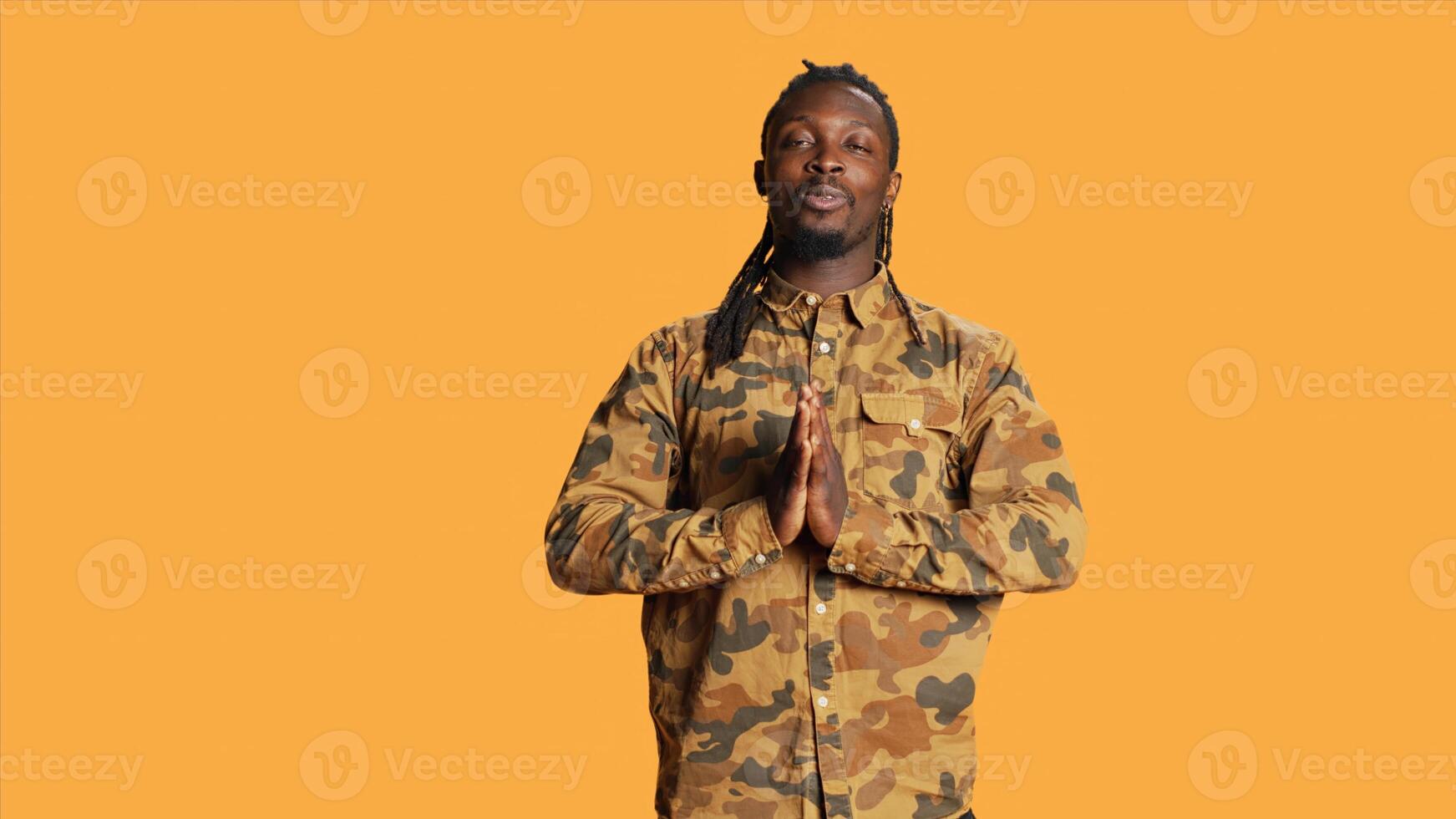 Male model doing breathing exercise over background, stylish person living healthy lifestyle in studio. African american guy inhales and exhales on camera, wellbeing concept. photo