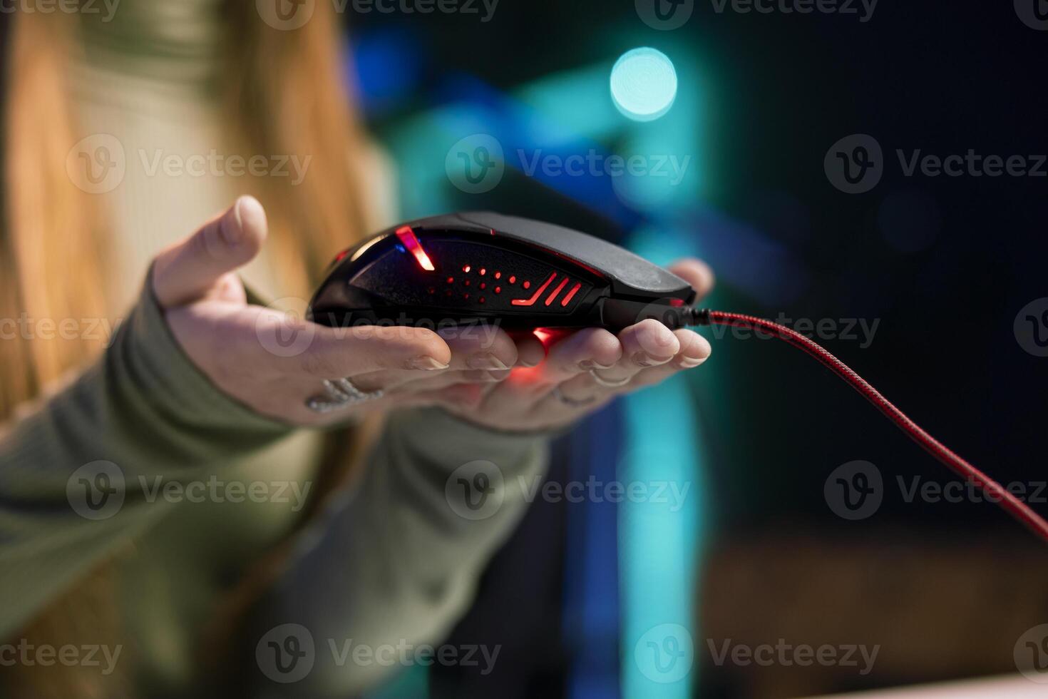 Media star filming review of newly released gaming led lights mouse, close up shot. Woman giving viewers feedback about computer peripheral performance, recording in home studio photo