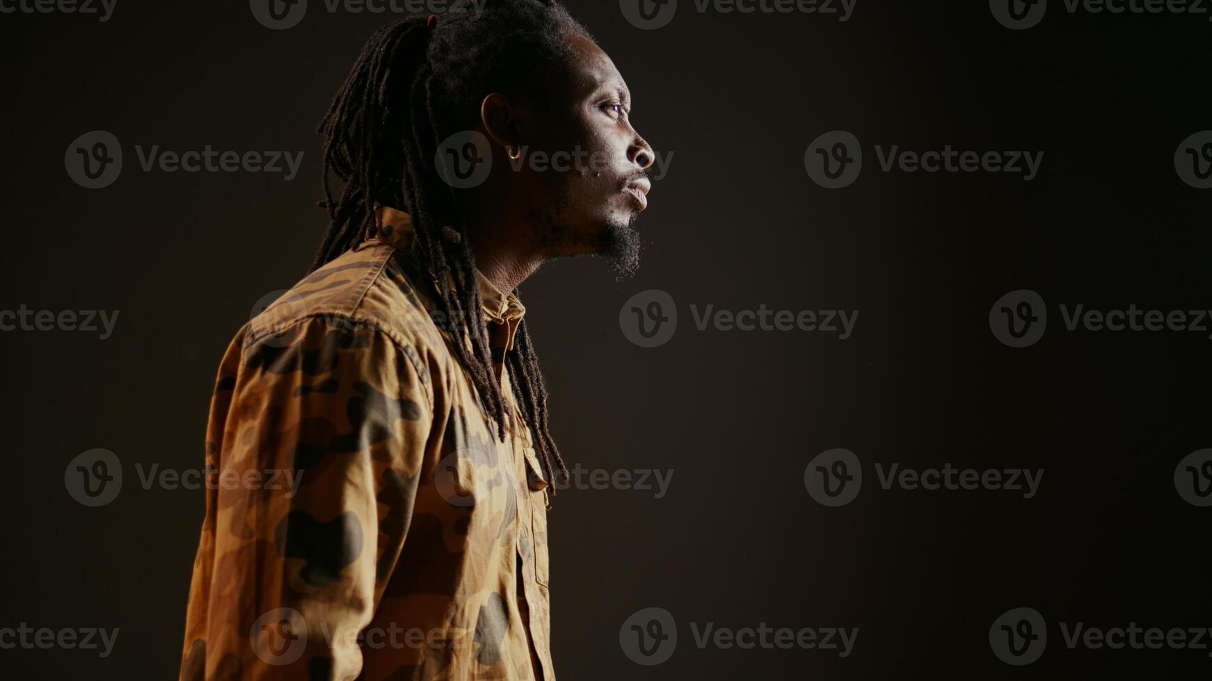 Trendy person with dreads acting shocked and amazed by view, seeing something and being surprised. African american adult admiring a thing and saying wow on camera. Handheld shot. photo