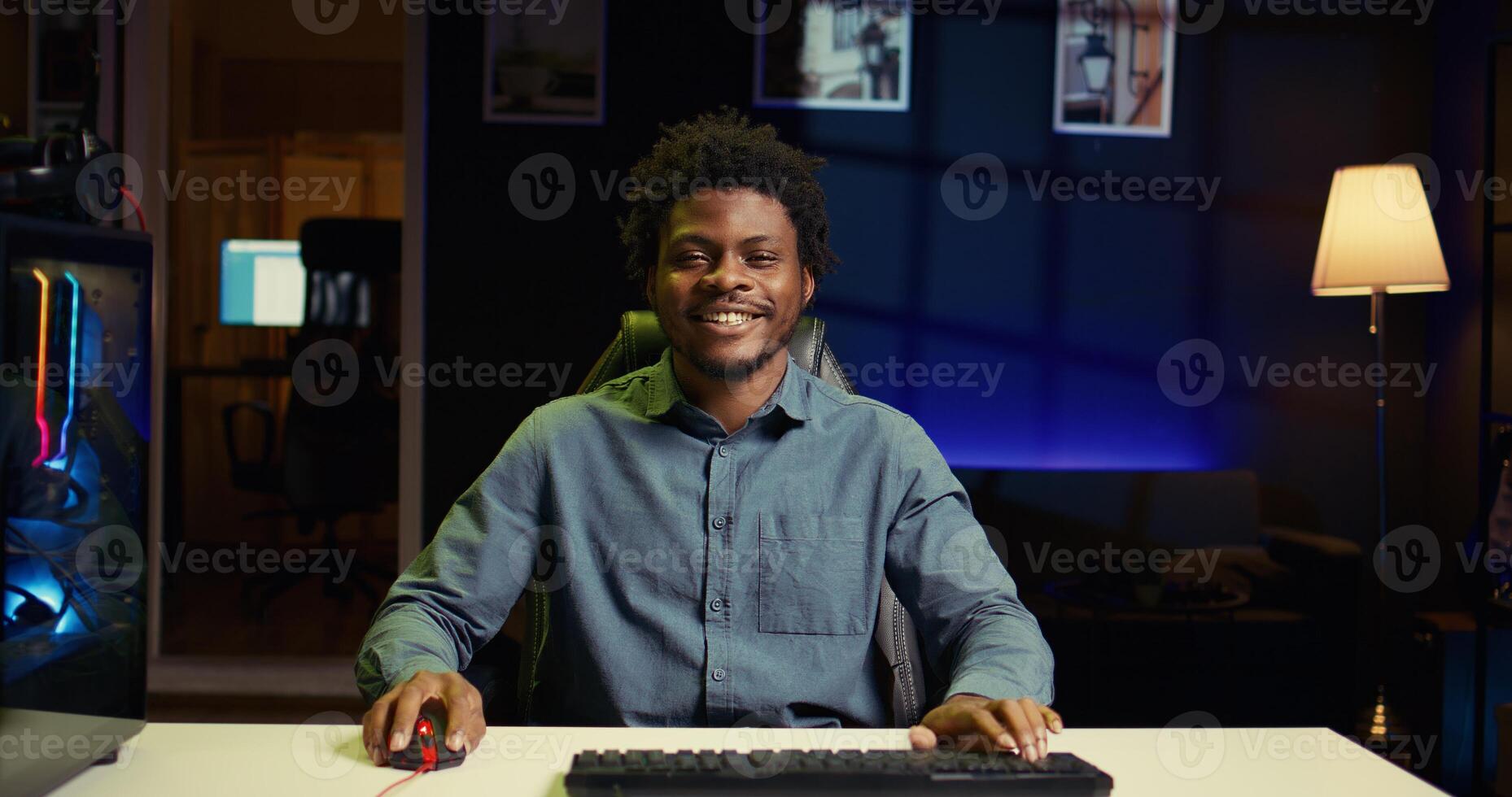 BIPOC man using gaming keyboard to play videogames at home, focused on winning. Gamer using neon lit PC and computer peripherals to compete in internet multiplayer game competition photo