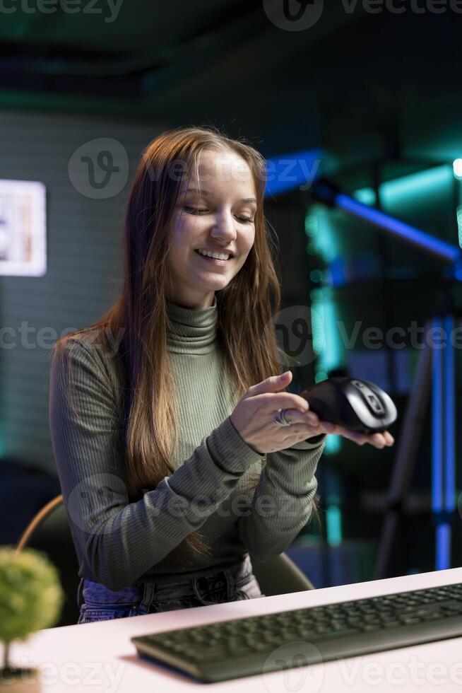 Cheerful gen Z content creator presenting mouse from brand sponsoring , urging viewers to buy it. Happy young internet star does influencer marketing by advertising computer peripherals photo