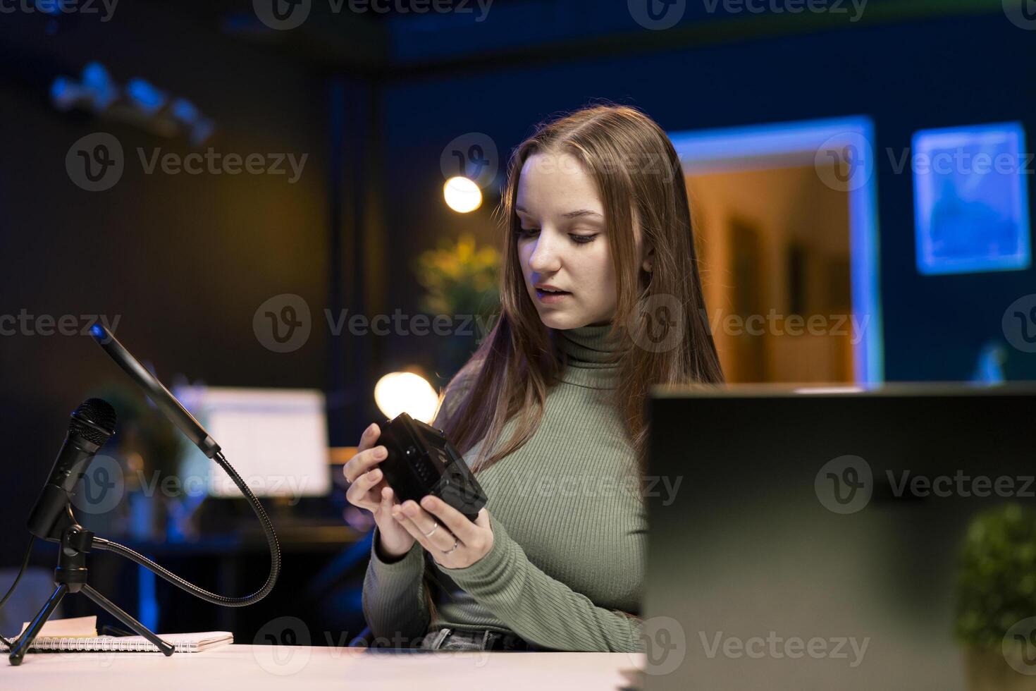Gen Z content creator reviews large capacity V mount battery used to power high end devices on niche online channel. Girl showcasing rechargeable portable lithium power source photo