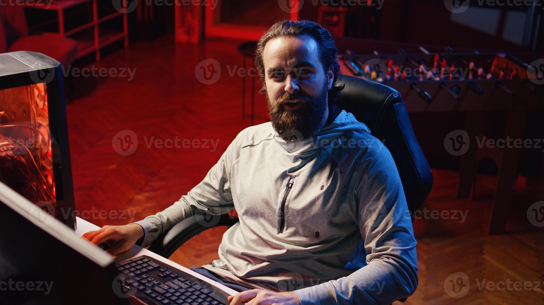 Content creator looking at webcam, chatting with audience while playing online multiplayer videogame on PC, contending against other live esports pro players, broadcasting game on internet for fans photo
