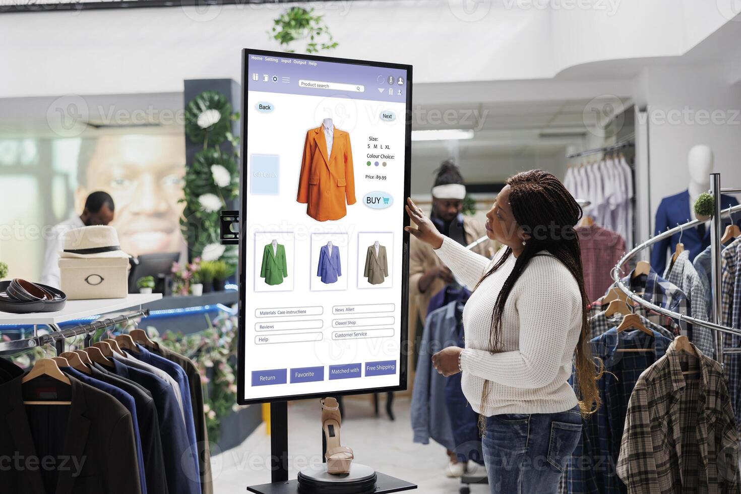 African american client selecting items to buy from self service checkout kiosk, reviewing modern clothes and sizes on interactive monitor. Young woman looking at products on board. photo
