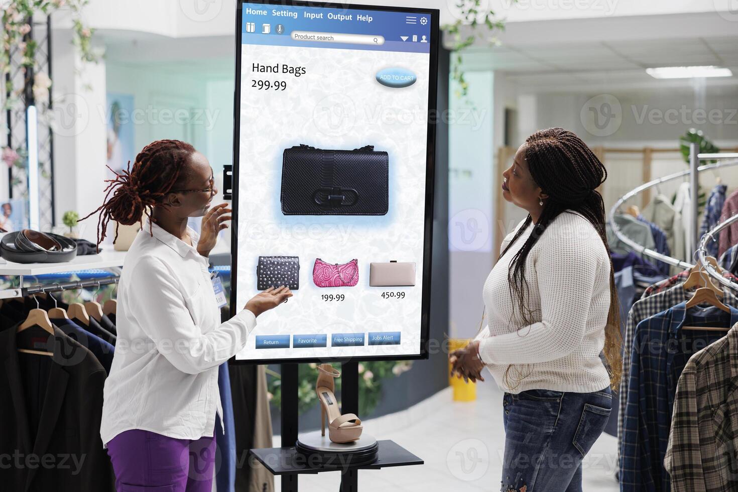 Store employee advising customer with kiosk service, assistant helping client in fashion boutique. Young buyer searching for clothing items on touch screen display board, retail shop. photo